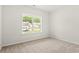 Bright bedroom featuring a large window with views of the neighborhood and plush carpeting at 3332 Little Bay Dr., Conway, SC 29526