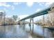 View of a long, green bridge that extends over a calm river surrounded by lush trees on a partly cloudy day at 3332 Little Bay Dr., Conway, SC 29526