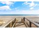 Beautiful beach view from the wooden stairs on a sunny day with blue skies and scattered clouds at 4 Catawba Ct., Myrtle Beach, SC 29588