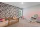 Cozy bedroom with a black and white leaf-patterned accent wall and a rocking chair at 4005 Sweetspire Court, Conway, SC 29526