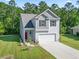Charming two-story home with a well-maintained lawn and a two-car garage, nestled among mature trees at 4005 Sweetspire Court, Conway, SC 29526