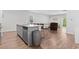 Open-concept kitchen with granite countertops, a gray island with seating, and hardwood flooring throughout at 4005 Sweetspire Court, Conway, SC 29526