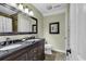 Bathroom with a dual sink vanity, framed mirror, tile floors, and decorative art, providing a clean and modern space at 407 15Th Ave. S, North Myrtle Beach, SC 29582