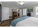 Airy primary bedroom showcasing large windows, hardwood floors, and modern ceiling fan at 407 15Th Ave. S, North Myrtle Beach, SC 29582