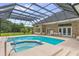 Expansive screened-in pool with hot tub alongside brick home and pristine outdoor space at 4084 Hagwood Circle, Conway, SC 29526