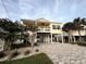 Elevated coastal home with a covered porch, tropical landscaping, and a spacious paved driveway at 412 29Th Ave. N, North Myrtle Beach, SC 29582