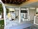 Covered outdoor patio with seating, hammock, string lights, and a grilling area for relaxed, coastal living at 412 29Th Ave. N, North Myrtle Beach, SC 29582