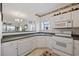 The white kitchen boasts a breakfast bar, stainless sink, and modern appliances at 4200 Coquina Harbour Dr. # H5, Little River, SC 29566