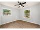 Bright bedroom with two windows, a ceiling fan, and beautiful wood-look flooring at 421 Villa Woods Dr., Myrtle Beach, SC 29579