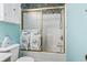 Compact bathroom showcasing a shower with glass doors, blue walls, and a white toilet and cabinet at 4616 Greenbriar Dr. # H-4, Little River, SC 29566