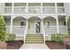 Charming building entrance with stairs, white railings, and well-maintained landscaping at 4616 Greenbriar Dr. # H-4, Little River, SC 29566