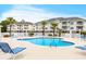 Resort-style pool area with lounge chairs and views of the condo buildings and palm trees at 4878 Luster Leaf Circle # 402, Myrtle Beach, SC 29577
