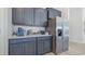Close up of a modern kitchen with stainless refrigerator, quartz counters and gray shaker cabinets at 512 Haven View Way, Murrells Inlet, SC 29576