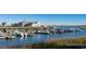 Picturesque marina view with boats docked near charming blue buildings under a clear sky at 512 Haven View Way, Murrells Inlet, SC 29576