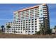 The multi-story exterior of an oceanfront hotel features multiple windows and balconies, offering scenic coastal views at 5300 N Ocean Blvd. # 310, Myrtle Beach, SC 29577