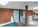 Hallway leading to unit, featuring wood paneled walls, light blue trim and door at 5601 N Ocean Blvd. # E-304, Myrtle Beach, SC 29577