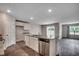 Open kitchen with center island, stainless steel appliances, and wood flooring at 572 Woodland Farms Circle, Aynor, SC 29511