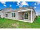 Back exterior featuring a covered patio, sliding glass door, and a well-maintained lawn at 572 Woodland Farms Circle, Aynor, SC 29511