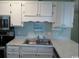 Clean, modern kitchen with stainless steel sink, faucet, and appliances, plus white cabinets at 5905 S Kings Hwy. # 314-B, Myrtle Beach, SC 29575