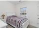 Bedroom with a bed with a blue and red striped quilt, a window and white night stand at 6001-1872 S Kings Hwy., Myrtle Beach, SC 29575