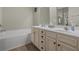 Bright main bathroom features double sinks, a large mirror, and a soaking tub at 713 Garland Ct., Myrtle Beach, SC 29588