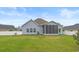 Back exterior featuring screened-in porch, grill, manicured lawn, and white vinyl fence at 713 Garland Ct., Myrtle Beach, SC 29588
