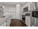 Modern kitchen featuring granite counters, stainless appliances, white cabinets, and dark wood flooring at 713 Garland Ct., Myrtle Beach, SC 29588