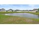 Calm pond situated in a green grassy yard with houses in the distance and blue sky at 713 Garland Ct., Myrtle Beach, SC 29588