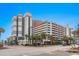 Multi-story condo building with palm trees and street view, featuring a parking garage with multiple levels at 7200 N Ocean Blvd. # 431, Myrtle Beach, SC 29572