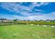 Expansive backyard with lush green grass, a serene pond, and a view of the community at 777 Woodland Farms Circle, Aynor, SC 29511