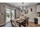 Dining area with dark wood table set for six, chandelier, and sliding glass door to the patio at 777 Woodland Farms Circle, Aynor, SC 29511