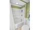 Bright bathroom showcasing a shower-tub combination with white tile and green textured wallpaper at 9820 Queensway Blvd. # 704, Myrtle Beach, SC 29572