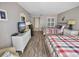 Inviting bedroom featuring two beds, wood floors, balcony access and modern decor at 9820 Queensway Blvd. # 704, Myrtle Beach, SC 29572