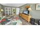 Relax in this bedroom featuring a colorful bedspread, wood floors, and a dresser with TV at 9820 Queensway Blvd. # 704, Myrtle Beach, SC 29572