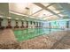Bright indoor pool area with tables, chairs, and a splash pad for ' entertainment at 9820 Queensway Blvd. # 704, Myrtle Beach, SC 29572