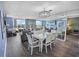 Open floor plan living room with a dining table, balcony access, and modern decor at 9820 Queensway Blvd. # 704, Myrtle Beach, SC 29572