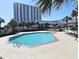 Relaxing outdoor pool with lounge chairs and palm trees, perfect for a sunny retreat at 9820 Queensway Blvd. # 704, Myrtle Beach, SC 29572