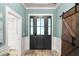 Inviting entryway featuring a stylish front door, wood floors, and a modern barn door at 1017 Gallinule Dr., Conway, SC 29526