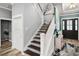 Elegant staircase with wooden steps, white railing, and a view into the entryway at 1017 Gallinule Dr., Conway, SC 29526