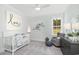 Cozy Bedroom features a white crib, comfortable seating, and natural light from the window at 1071 Milford Way, Myrtle Beach, SC 29588