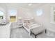 Bright bedroom with a large window, a white bed and a gray cushioned bench at the foot of the bed at 1071 Milford Way, Myrtle Beach, SC 29588