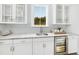 Bright kitchenette features a wet bar, granite countertops, stainless steel wine cooler, and window view at 1071 Milford Way, Myrtle Beach, SC 29588