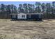 New construction home featuring dark siding, white trim, and a spacious yard at 116 Forman Way, Aynor, SC 29511