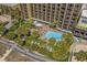 Aerial view of condo building, pool and boardwalk with lush tropical landscaping and ocean views at 1200 N Ocean Blvd. # 710, Myrtle Beach, SC 29577