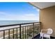 Relaxing balcony view overlooking the beach with blue skies and a glimpse of vegetation below at 1200 N Ocean Blvd. # 710, Myrtle Beach, SC 29577