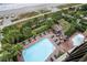 Aerial view of the pool area with lounge chairs and lush palm trees overlooking the beach at 1200 N Ocean Blvd. # 710, Myrtle Beach, SC 29577