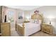 Bright bedroom featuring a detailed wooden bed frame, soft pink bedding, and ample natural light at 1204 River Oak Dr. # 25-A, Myrtle Beach, SC 29579