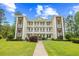 Building 21 boasts an attractive facade, multiple balconies, and is framed by a lush green lawn and bright blue skies at 1204 River Oak Dr. # 25-A, Myrtle Beach, SC 29579