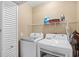 Functional laundry room with a washer, dryer, storage shelves, and tiled flooring at 1204 River Oak Dr. # 25-A, Myrtle Beach, SC 29579