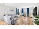 Bright living room featuring a plush gray sofa, hardwood floors, and eye-catching blue curtains at 1204 River Oak Dr. # 25-A, Myrtle Beach, SC 29579